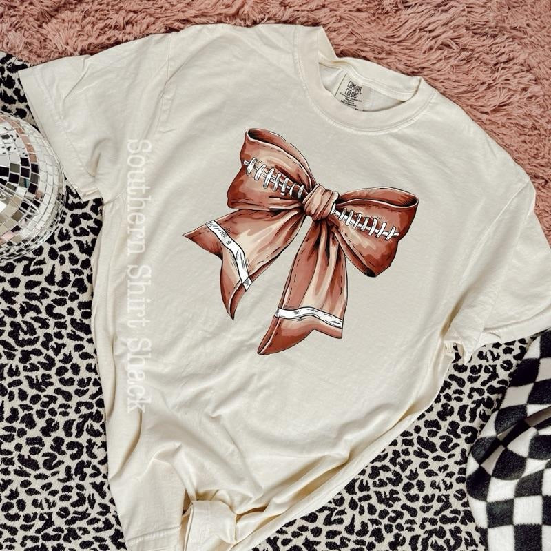 Football bow | ivory comfort colors t shirt Hoodie Sweatshirt | PrintMintTees.com